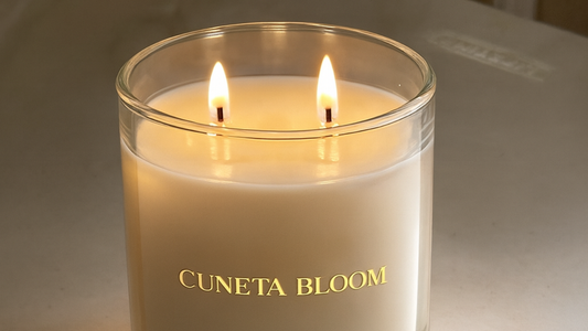 Cuneta Bloom luxury candle in a clear glass jar with double cotton wicks, displayed beside its cream packaging, hand-poured by Grice Wax & Wicks.