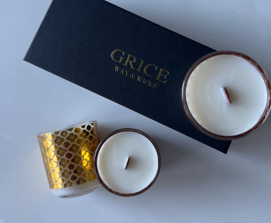 Flat lay of luxury candles from Grice Wax & Wicks with a gold votive and black box.