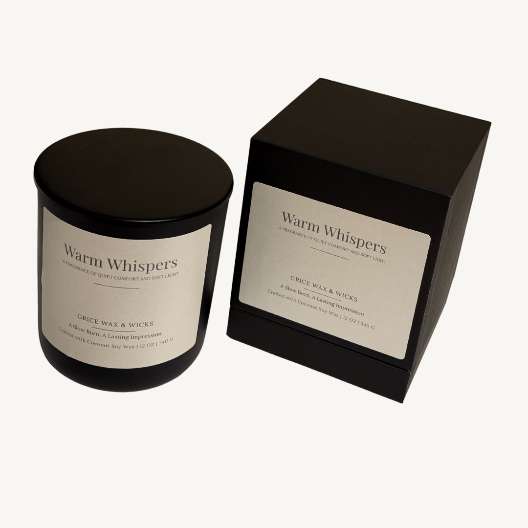 Candle labeled ‘warm whispers’ beside dried lavender and sage, styled with soft textures and neutral tones to evoke calm, comfort, and quiet grounding.