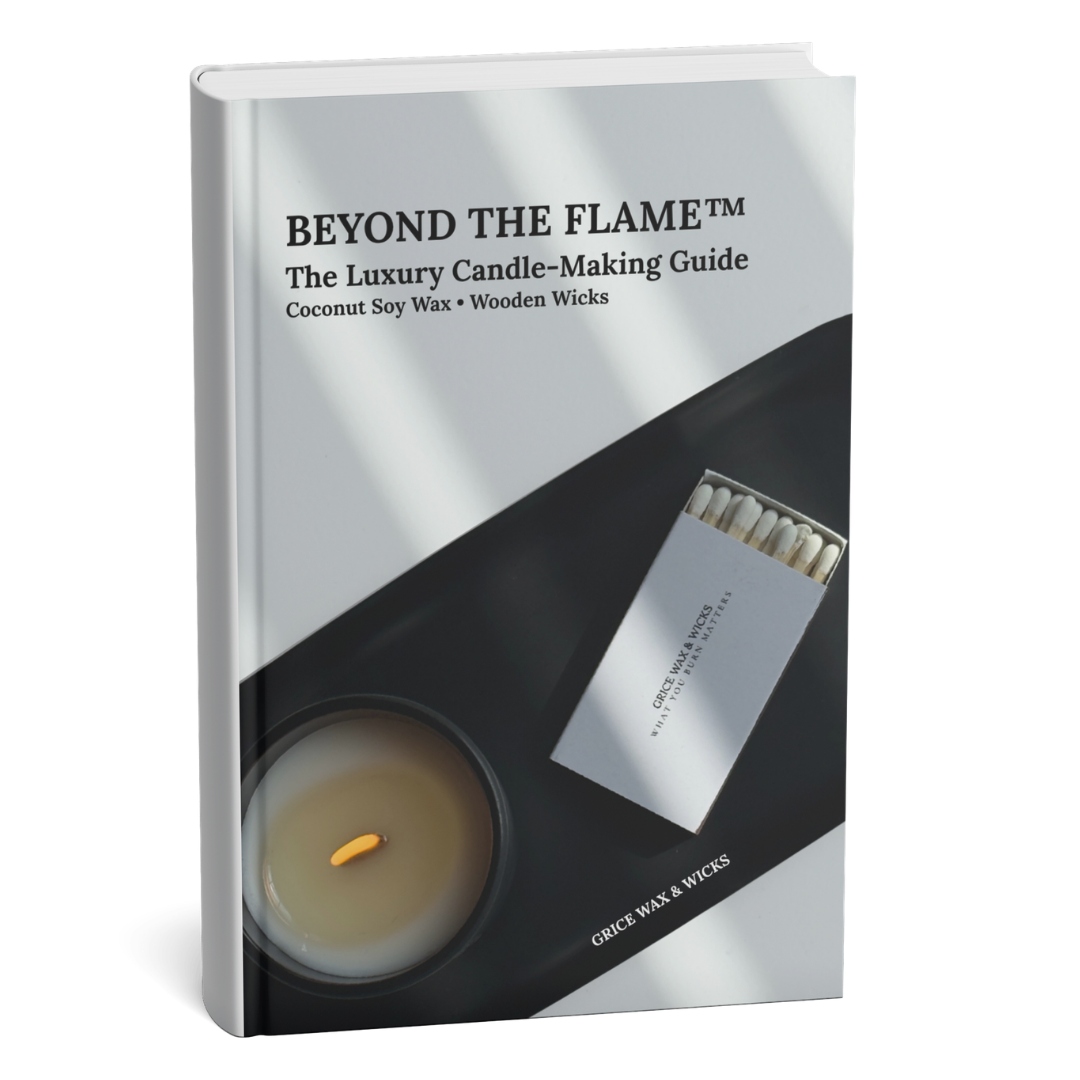 A hardcover book titled 'BEYOND THE FLAME™ The Luxury Candle-Making Guide' by Grey Wax & Wicks, shown standing upright on a white background. The cover is white and black with a photo of a candle and a matchbook.