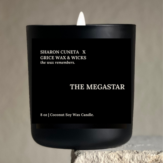 Black candle labeled 'The Megastar' by Sharon Cuneta x Grice Wax & Wicks on a neutral background.