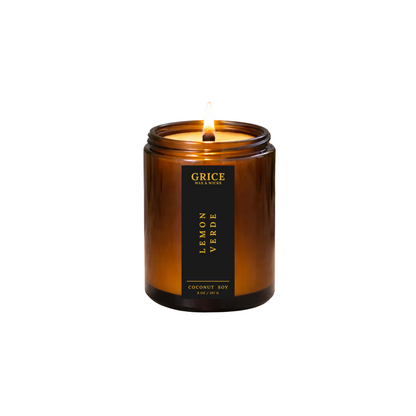 Candle in an amber jar with a black label on a white background