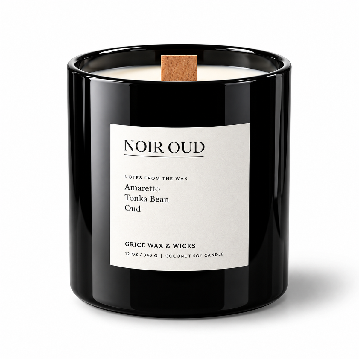 A black glass jar candle with a white label reading 'NOIR OUD' and a small wooden wick, photographed on a clean white background.