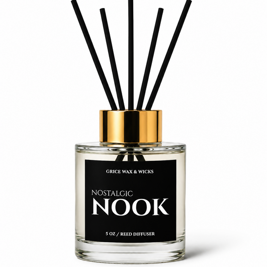 Grace Wax & Wicks Nostalgic Nook reed diffuser in a clear glass bottle with a black label, gold cap, and six black reeds, on a white background.