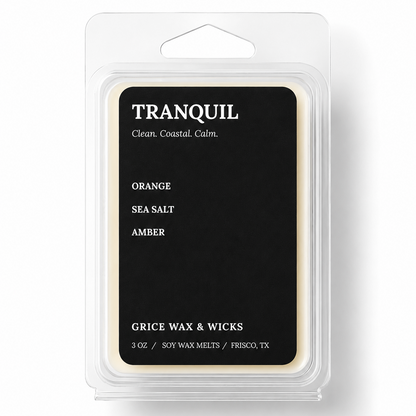 A 3 oz package of Tranquil Scents soy wax melts in the Orange Sea Salt Amber scent, featuring a black label with white text inside a clear plastic clamshell container.